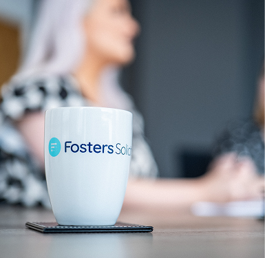 Fosters Solicitors mug on a table with a client in the background