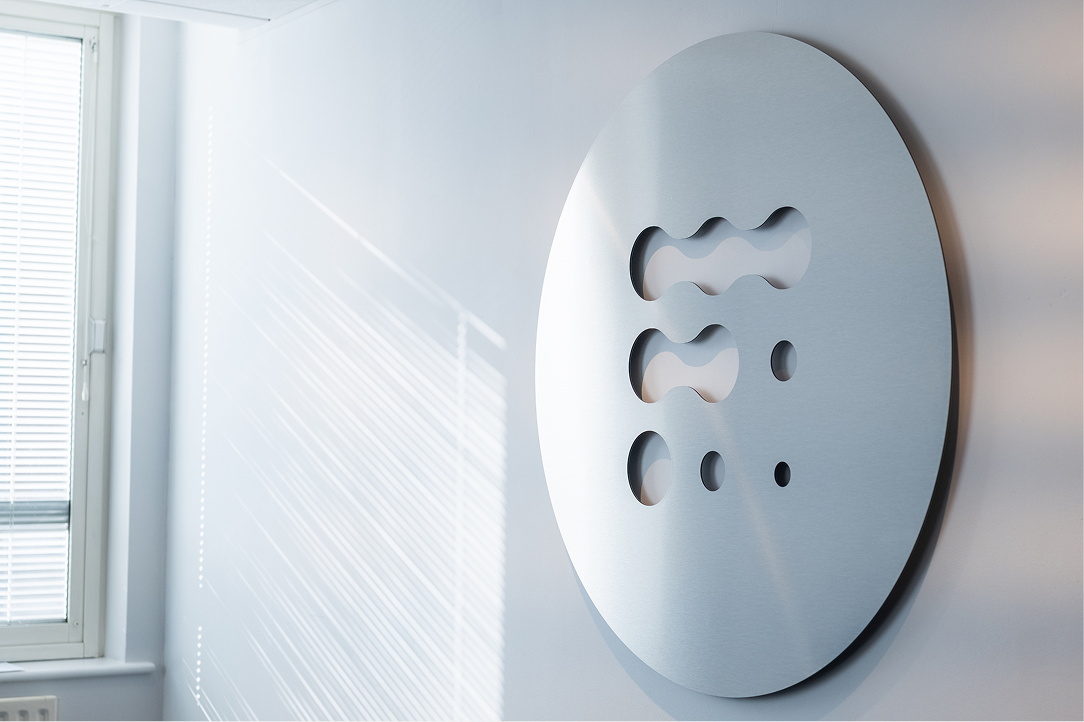 Decorative perforated metal panel on an office wall beside a window