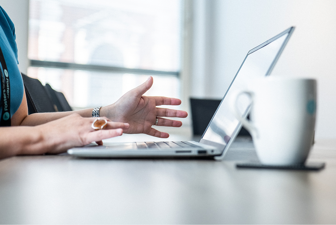 Client gesturing during a video call on a laptop at a desk