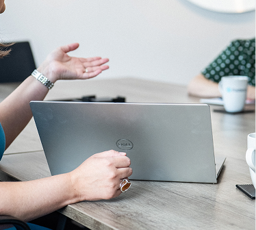 Client gesturing during a video call on a laptop at a desk