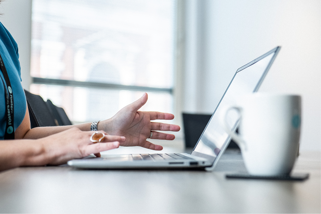 Client gesturing during a video call on a laptop at a desk