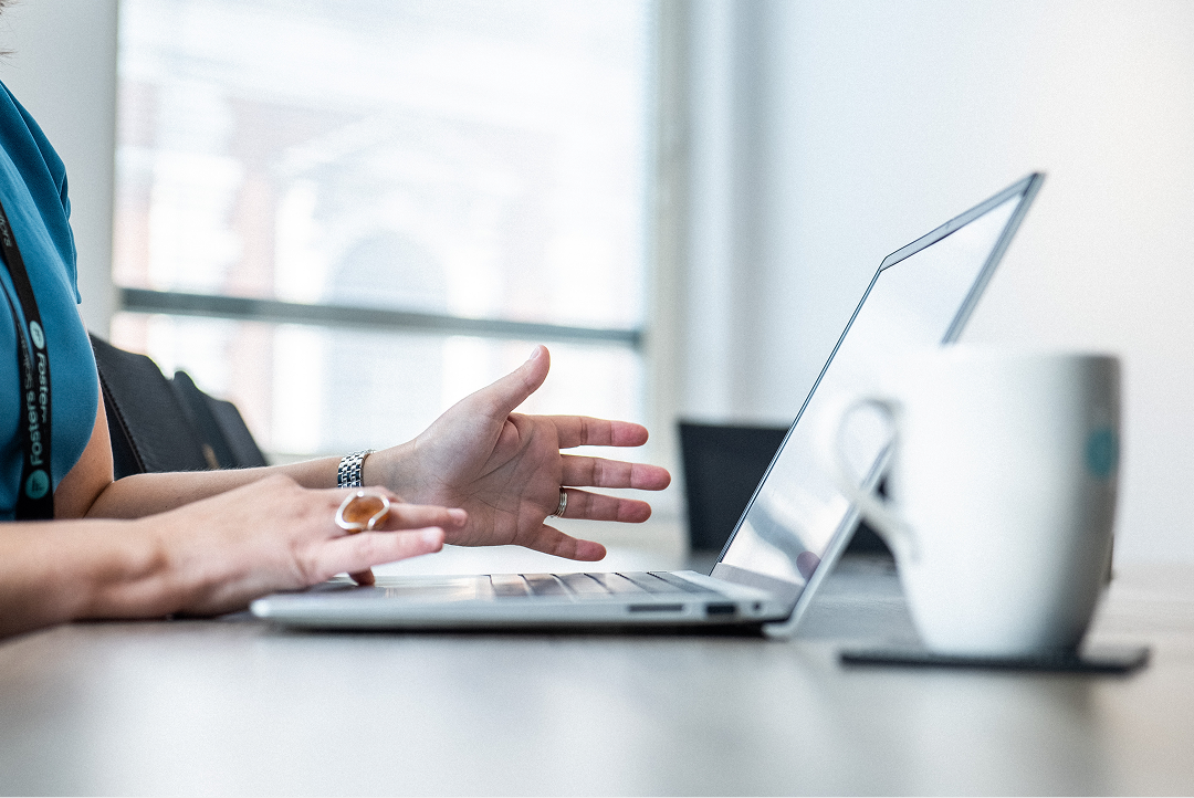 Client gesturing during a video call on a laptop at a desk
