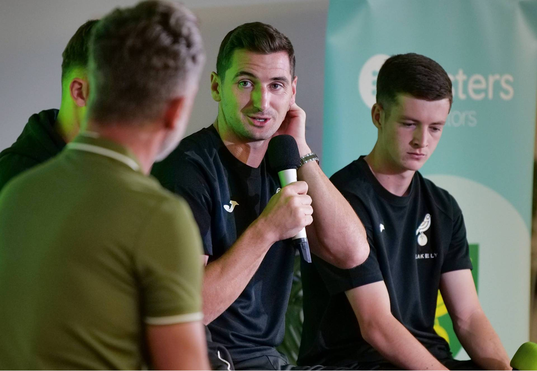 Norwich City players being interviewed in front of a Fosters Solicitors branded backdrop