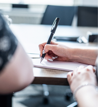 Close-up of a client signing a document with a pen