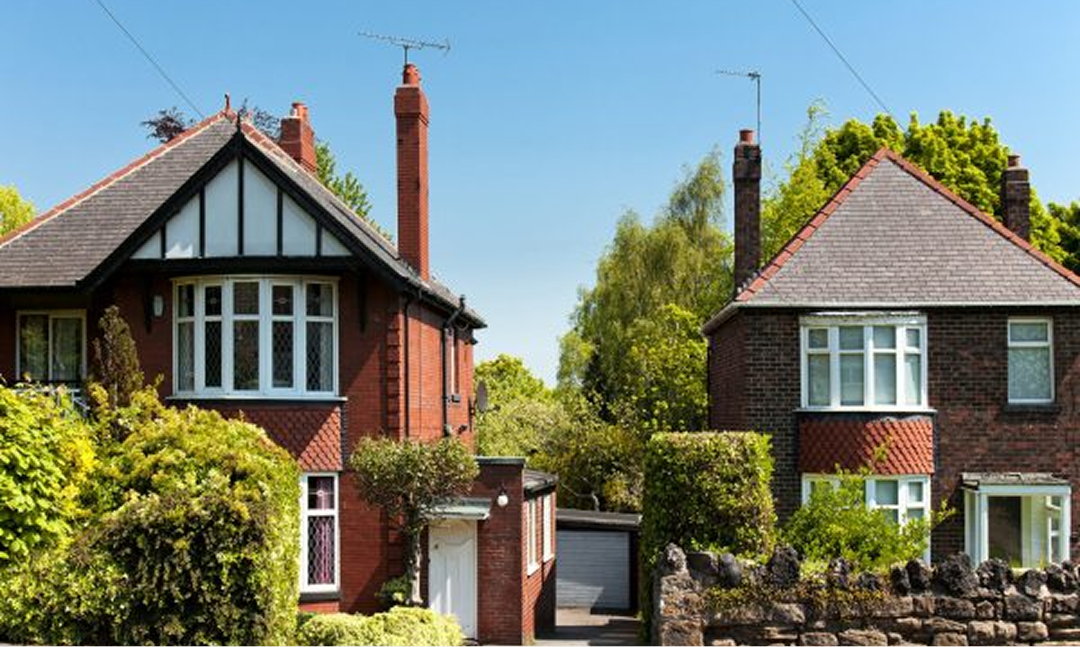 Two red-brick semi-detached houses on a residential street