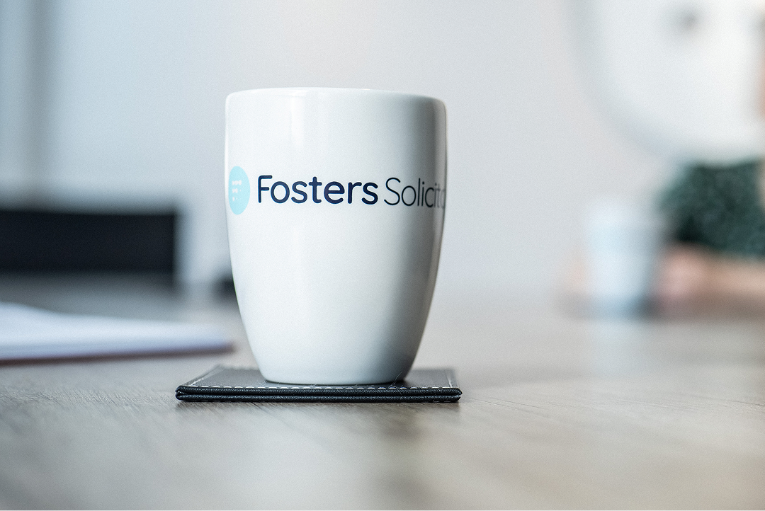 Fosters Solicitors mug on a desk near a window
