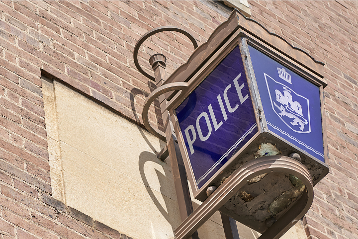 Traditional blue Police station lamp mounted on a brick wall