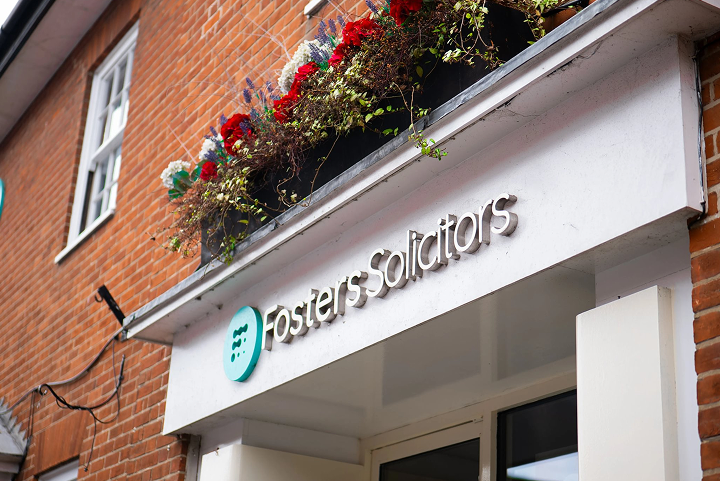 Fosters Solicitors office signage above the entrance with hanging flower baskets